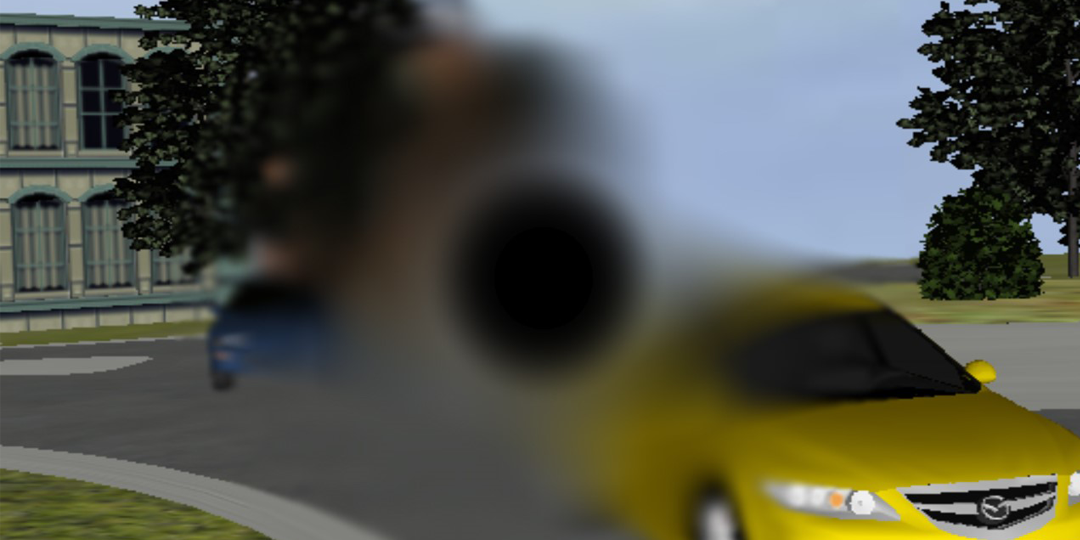 A central scotoma is simulated using a radial opacity and blur field at the center of the screen. The dark opacity is circumscribed by the blur field. The view of two cars in a virtual environment roundabout are obscured.
